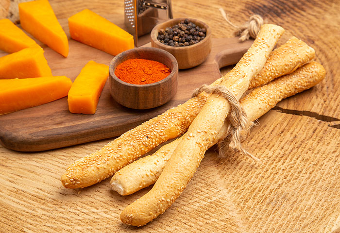 bottom view slices of cheese box grater spices on cutting board Derruso Breadsticks